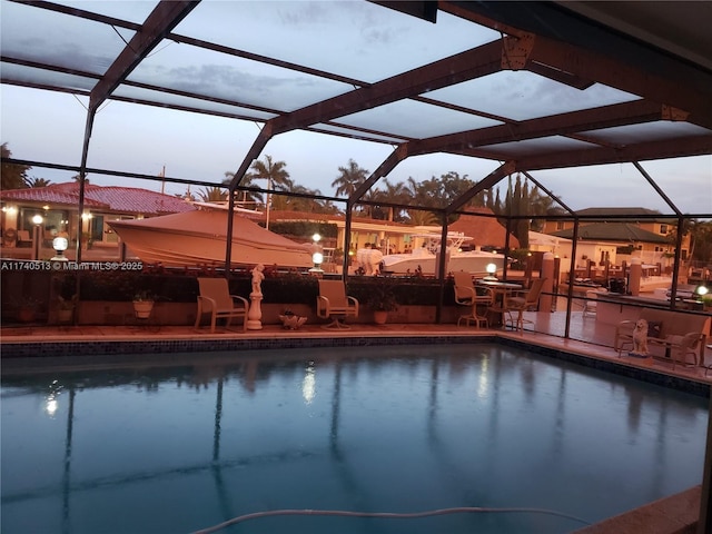 pool with glass enclosure and a patio area