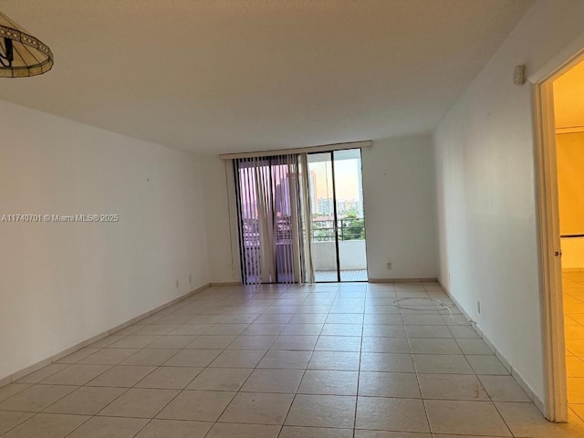 tiled spare room featuring floor to ceiling windows