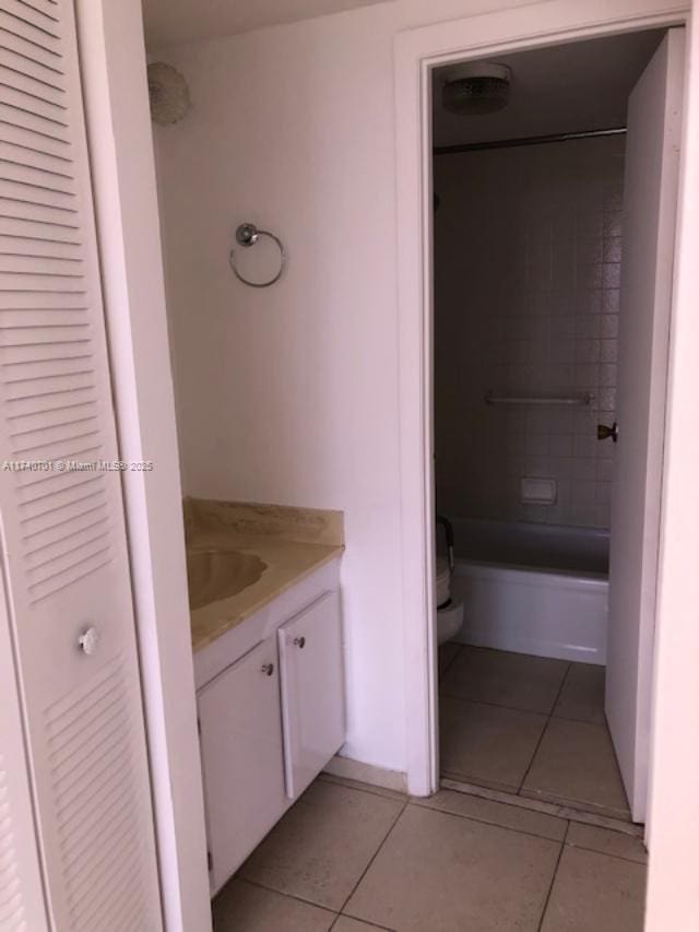 full bathroom with tile patterned flooring, vanity, tiled shower / bath combo, and toilet