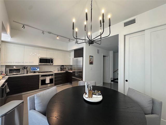 tiled dining room featuring rail lighting