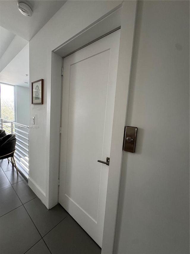 hall with dark tile patterned floors