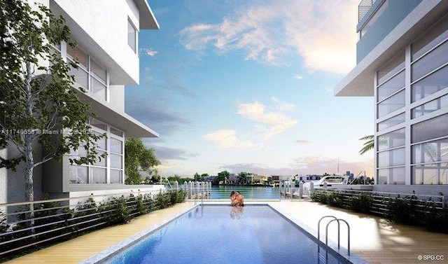 pool at dusk featuring a patio and a water view