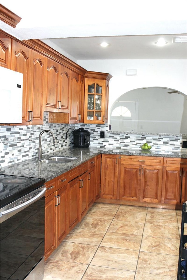 kitchen with sink, dark stone countertops, decorative backsplash, and stainless steel electric range