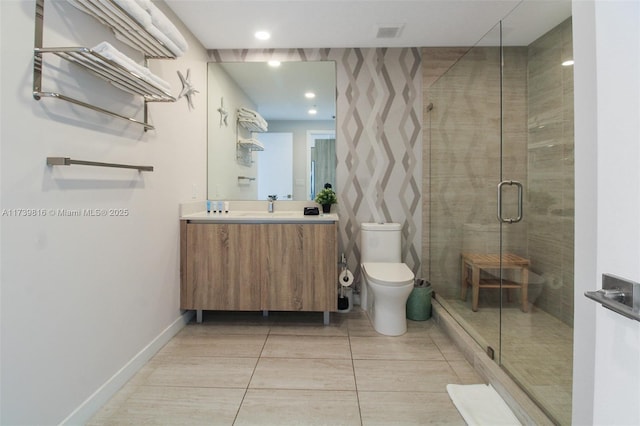 bathroom featuring walk in shower, vanity, toilet, and tile patterned flooring