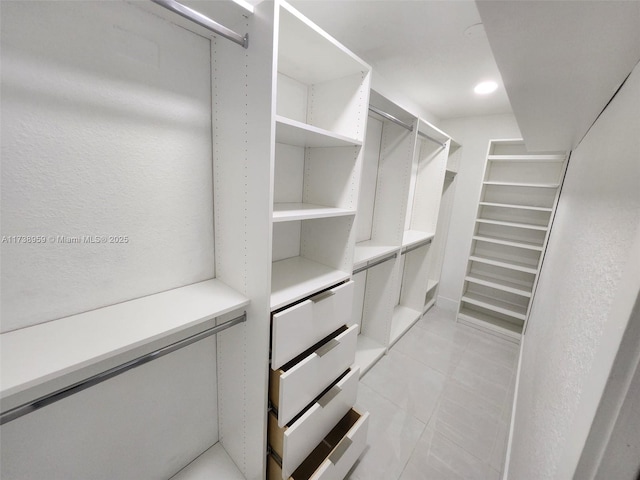 walk in closet with light tile patterned floors