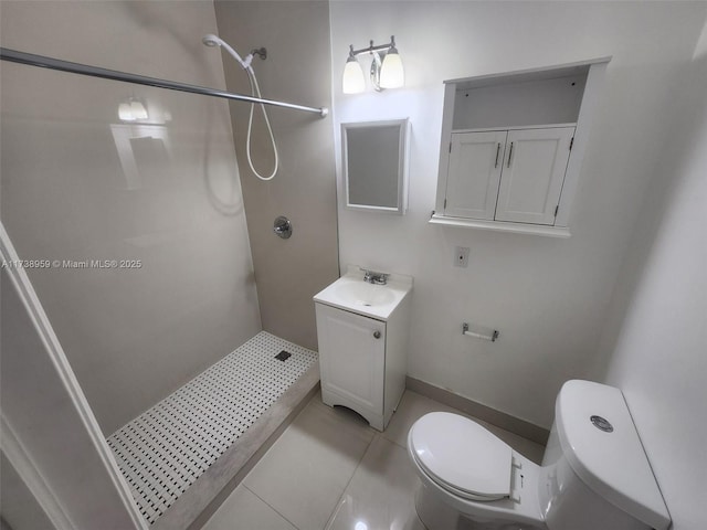 bathroom featuring a tile shower, vanity, tile patterned floors, and toilet