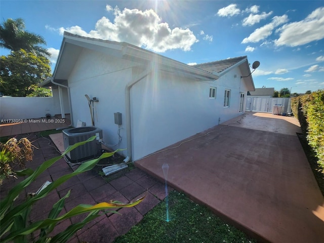 view of home's exterior with cooling unit and a patio area