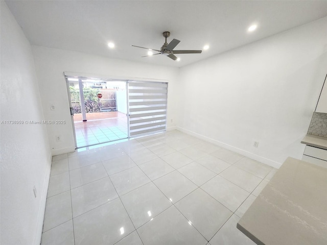 tiled spare room featuring ceiling fan