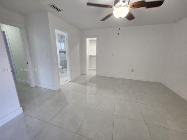 tiled spare room with ceiling fan