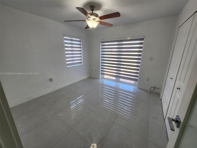 spare room featuring ceiling fan and light tile patterned floors