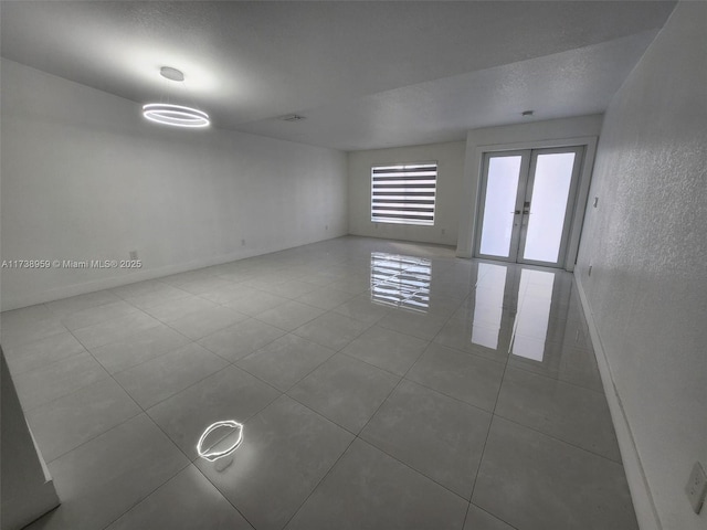 tiled empty room featuring a textured ceiling