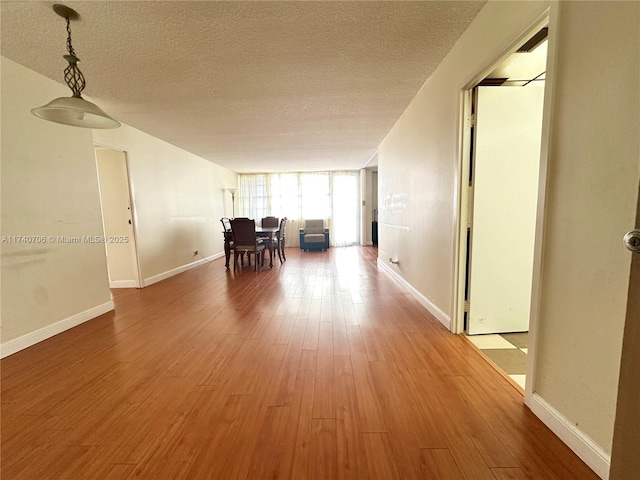 hall featuring hardwood / wood-style flooring, floor to ceiling windows, and a textured ceiling