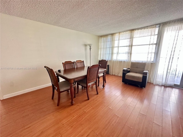 dining space featuring hardwood / wood-style flooring and a textured ceiling