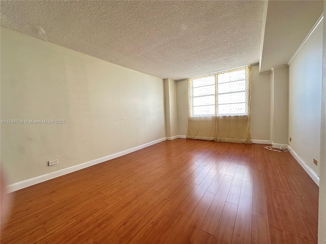 unfurnished room with wood-type flooring and a textured ceiling