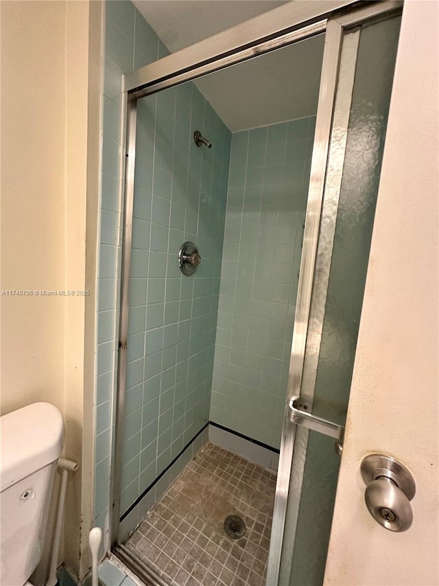 bathroom featuring walk in shower and toilet