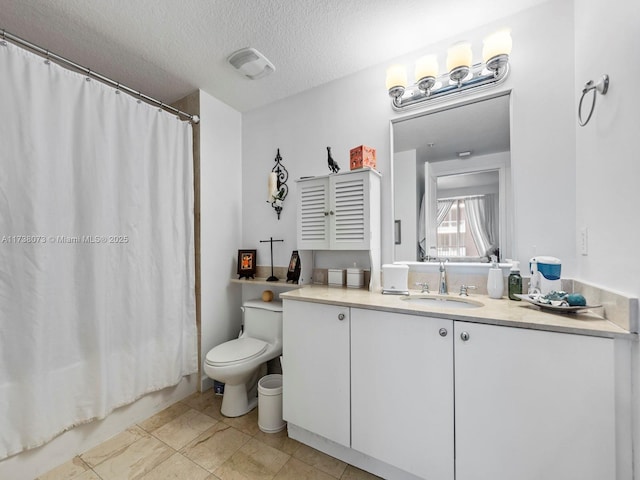 bathroom featuring vanity, toilet, and a textured ceiling