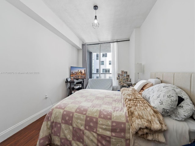 bedroom featuring expansive windows, dark hardwood / wood-style flooring, and access to exterior