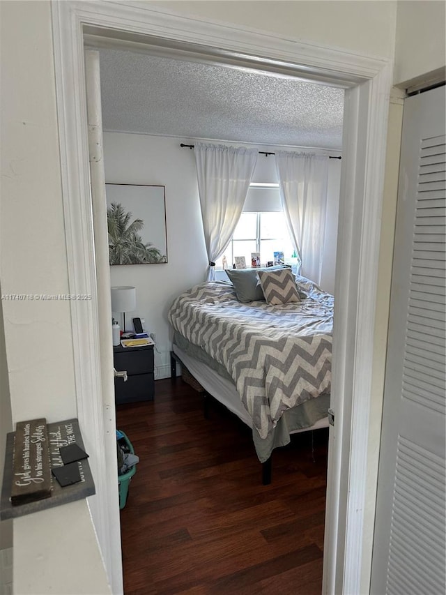 bedroom featuring dark hardwood / wood-style floors and a textured ceiling