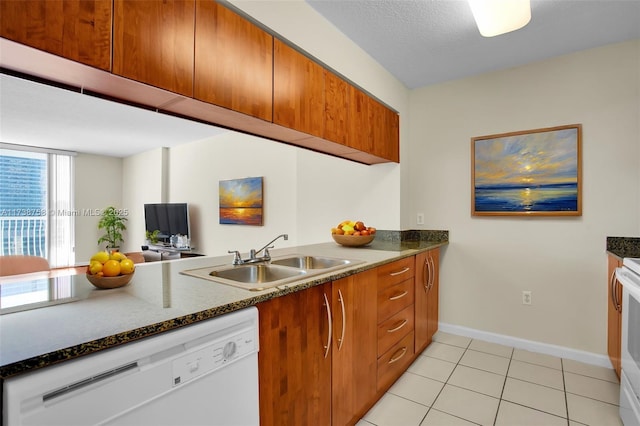 kitchen featuring sink, white appliances, a textured ceiling, and light tile patterned flooring