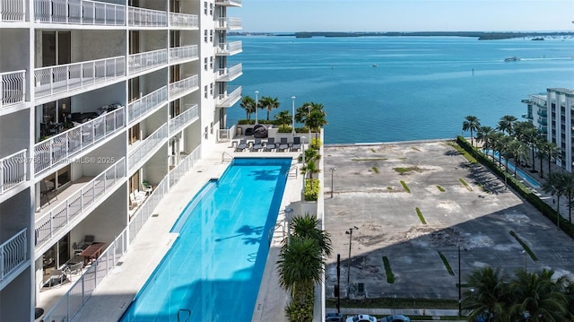 view of swimming pool with a patio and a water view