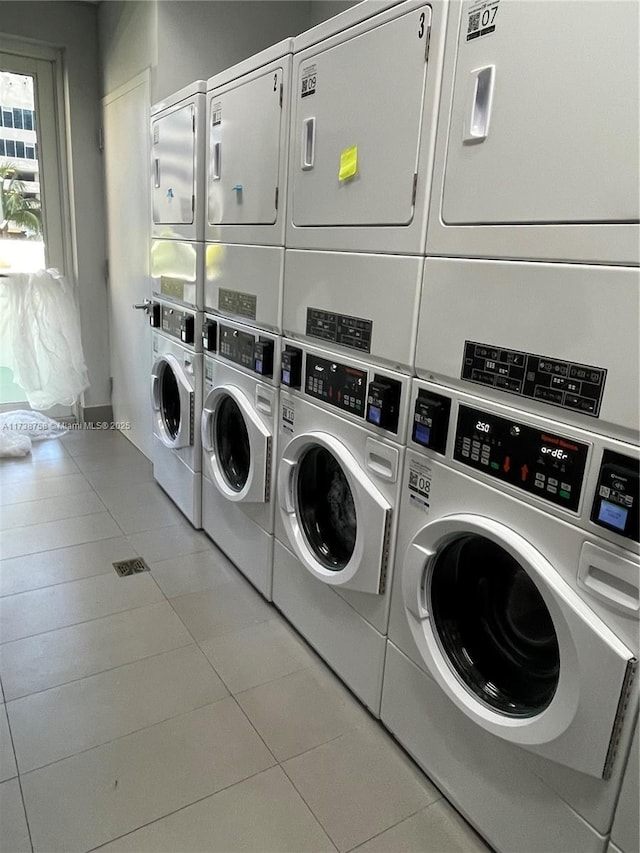 laundry area featuring washer and dryer, light tile patterned floors, and stacked washer and clothes dryer