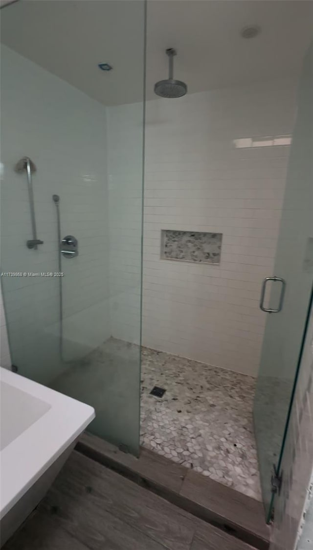 bathroom with walk in shower and hardwood / wood-style flooring