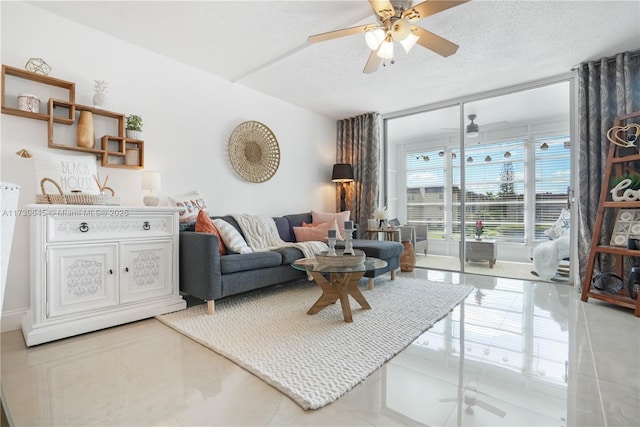 living room featuring ceiling fan, a wall of windows, a textured ceiling, and light tile patterned floors