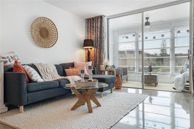 living room featuring ceiling fan, a textured ceiling, and a wealth of natural light