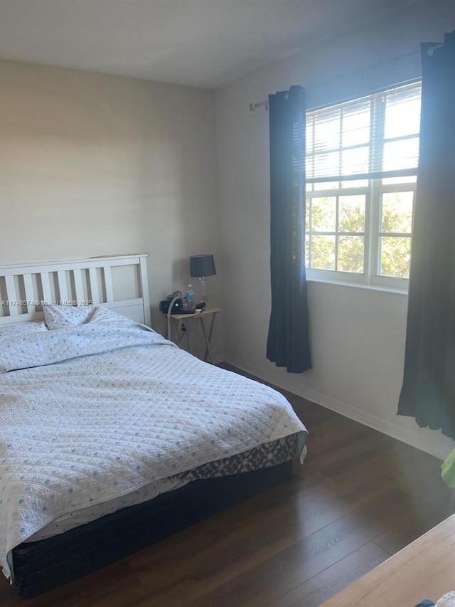 bedroom with dark wood-type flooring