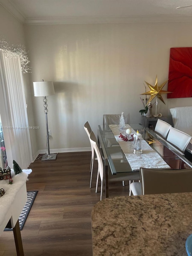 dining space with ornamental molding and dark hardwood / wood-style floors