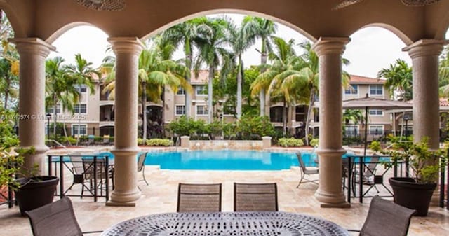 view of swimming pool featuring a patio and ceiling fan