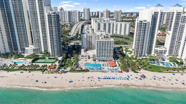 birds eye view of property with a water view and a beach view