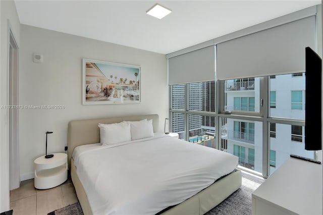 bedroom with expansive windows, multiple windows, and light tile patterned floors