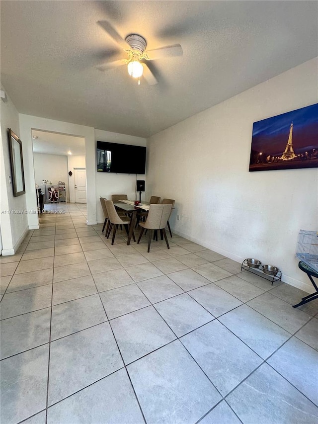 tiled dining area featuring ceiling fan and a textured ceiling