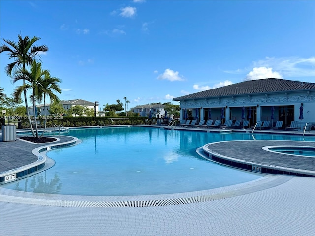 view of swimming pool with a hot tub and a patio