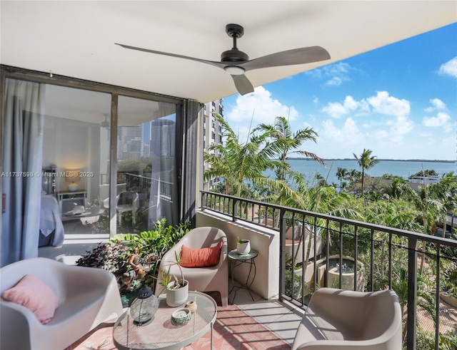 balcony with a water view and ceiling fan