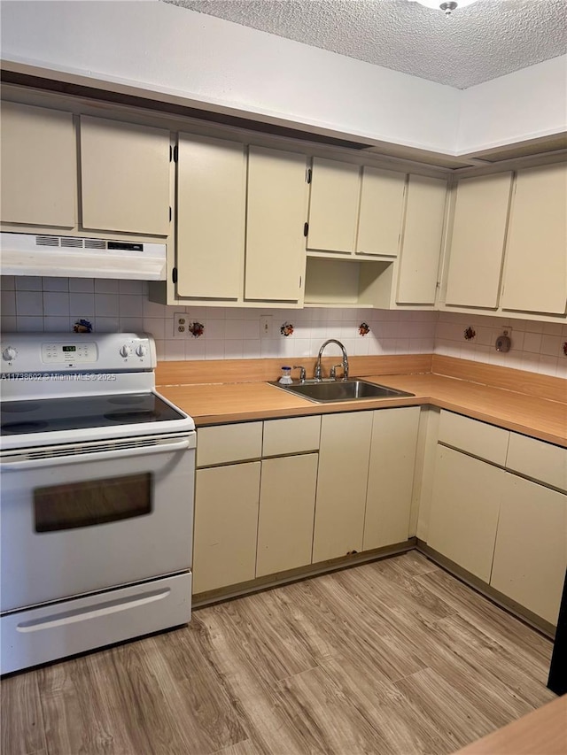 kitchen with white electric stove, sink, backsplash, cream cabinets, and light wood-type flooring