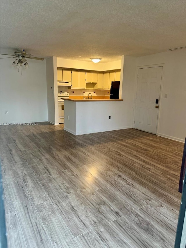 unfurnished living room featuring ceiling fan, a textured ceiling, and light wood-type flooring