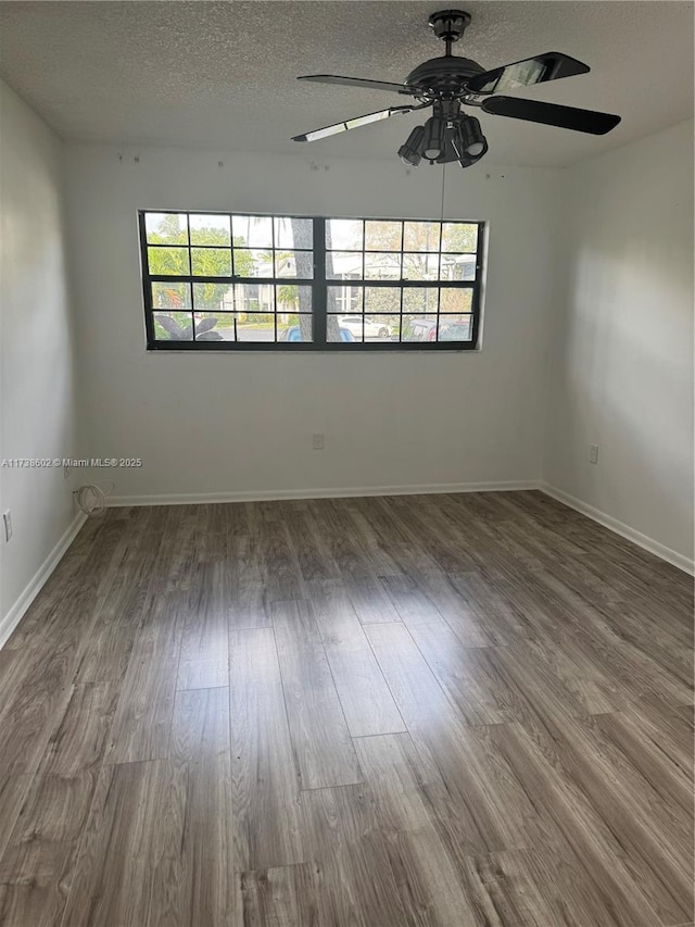 spare room featuring dark hardwood / wood-style floors and a textured ceiling