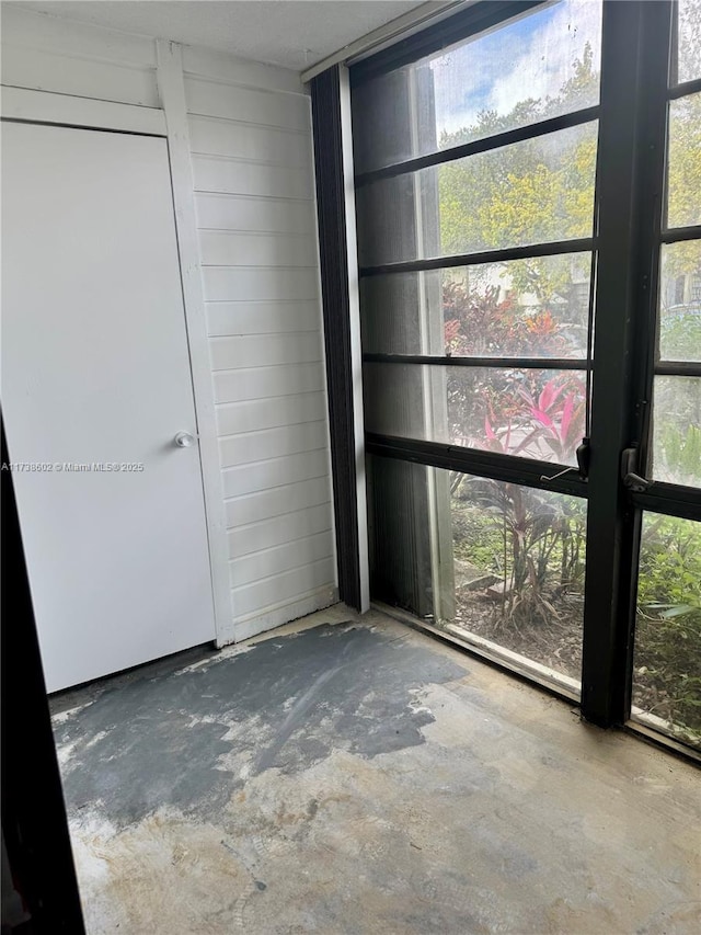 interior space with concrete flooring and wood walls