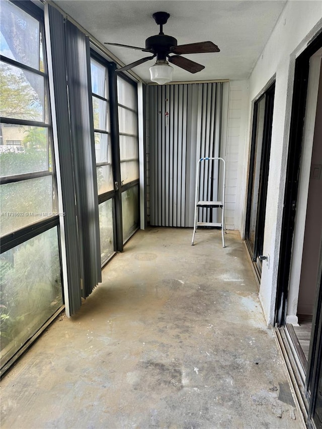 unfurnished sunroom featuring ceiling fan