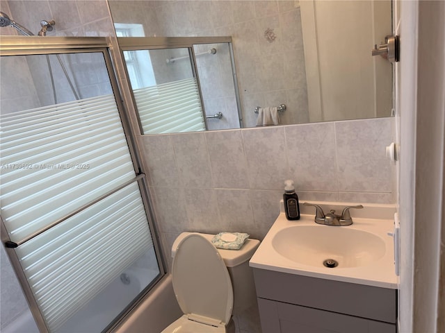 full bathroom with bath / shower combo with glass door, tasteful backsplash, tile walls, vanity, and toilet