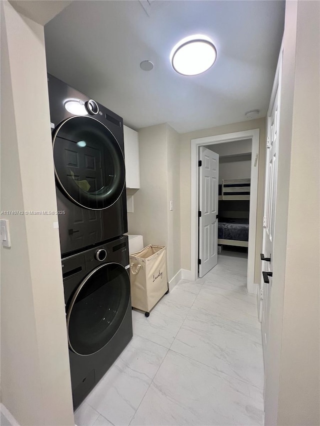 washroom featuring stacked washing maching and dryer