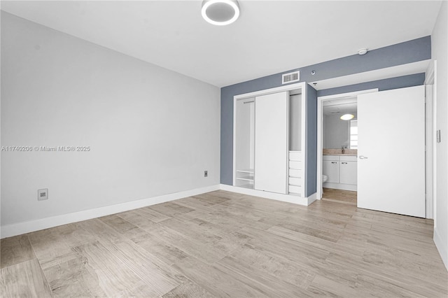 unfurnished bedroom featuring a closet and light wood-type flooring