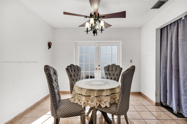 dining space with french doors, ceiling fan, a textured ceiling, and light tile patterned floors