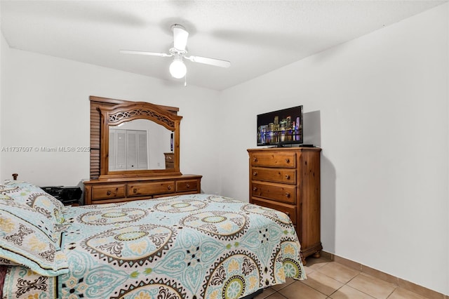 tiled bedroom featuring ceiling fan