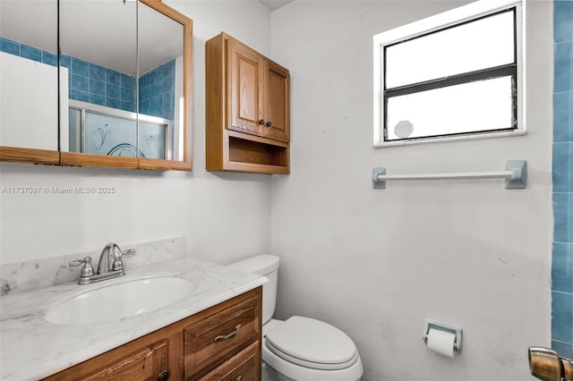 bathroom featuring vanity, toilet, and walk in shower