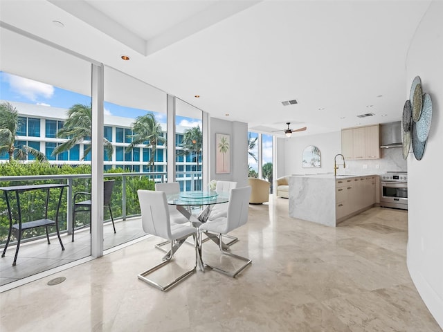 dining space with sink, floor to ceiling windows, and ceiling fan