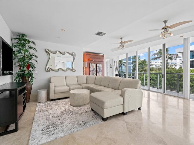 living room with expansive windows and ceiling fan