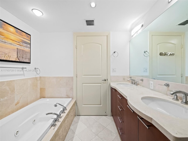 bathroom featuring a relaxing tiled tub and vanity